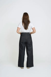 Woman wearing the Wide-Leg Jeans sewing pattern from The Assembly Line on The Fold Line. A jeans pattern made in medium to heavy weight fabric, featuring a high rise waist, zip fly, dropped crotch, front and back pockets, and wide legs.
