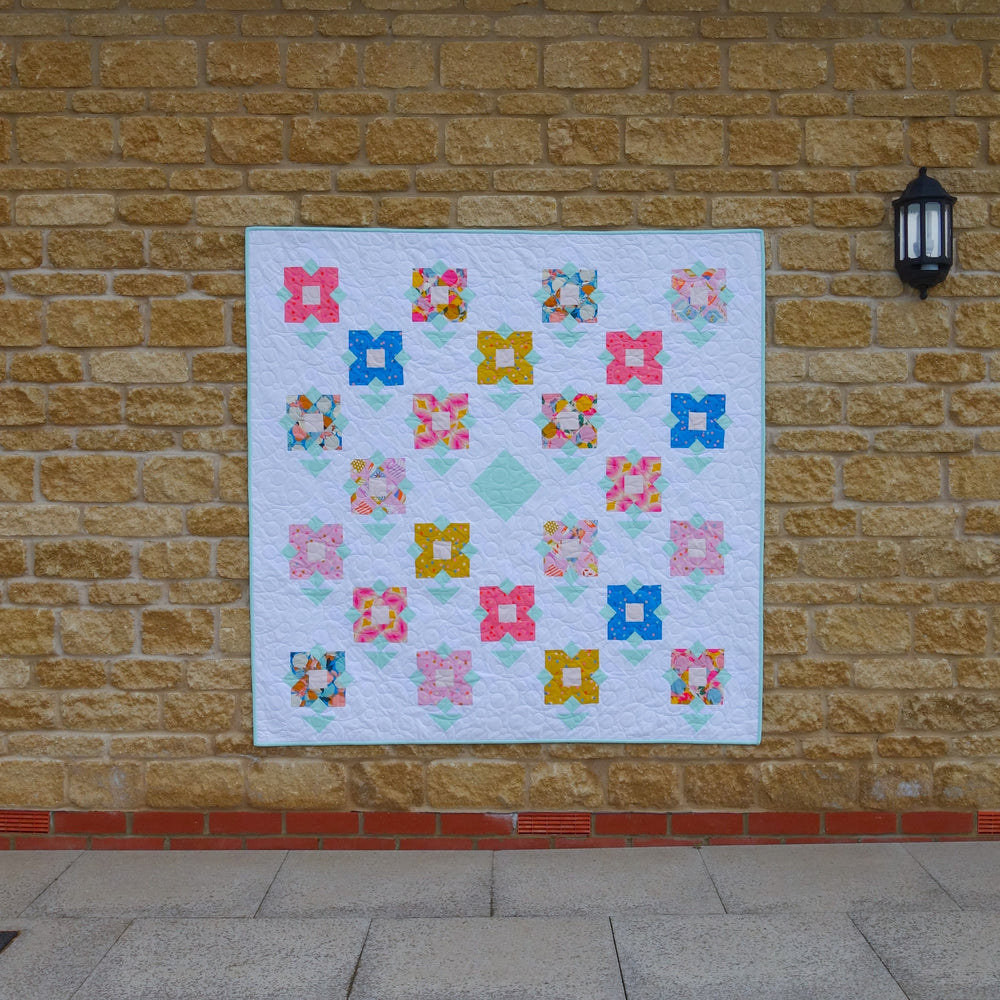 The Wildflower Meadow Quilt sewing pattern from Lou Orth Designs on The Fold Line. A quilt pattern made in quilting cotton fabric, featuring flower blocks arranged on point.