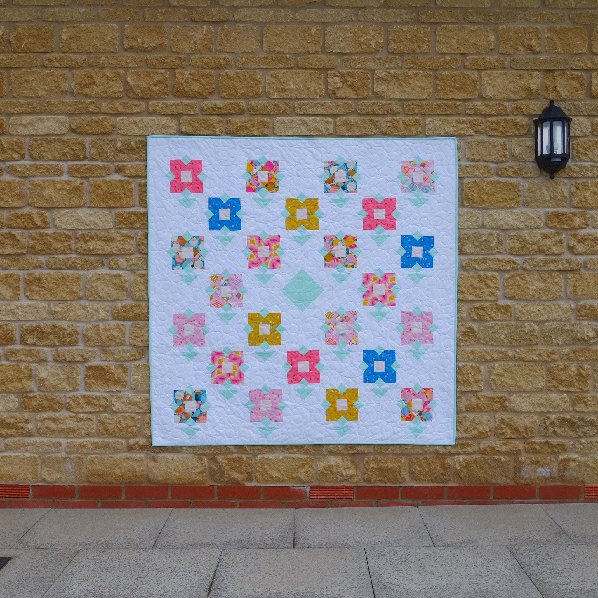 The Wildflower Meadow Quilt sewing pattern from Lou Orth Designs on The Fold Line. A quilt pattern made in quilting cotton fabric, featuring flower blocks arranged on point.