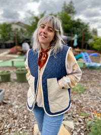 Woman wearing the Winona Vest sewing pattern from Daisy Chain Patterns on The Fold Line. A vest pattern made in cotton twill or canvas, denim, wool coating, water-resistant nylon, cotton lawn or poplin, quilting cotton, linen or linen blend fabric, featuring a straight fit, V-neckline, quilted body with bias bound edges, and double decker pockets.