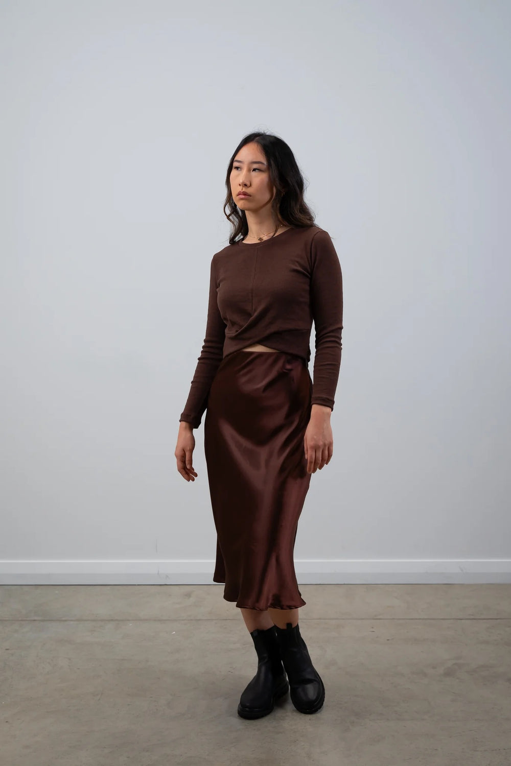 Woman wearing the Wolfe Top sewing pattern from Elbe Textiles on The Fold Line. A top pattern made in knit fabric, featuring a round neckline, crossover front panels, long sleeves, and cropped length.
