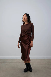 Woman wearing the Wolfe Top sewing pattern from Elbe Textiles on The Fold Line. A top pattern made in knit fabric, featuring a round neckline, crossover front panels, long sleeves, and cropped length.