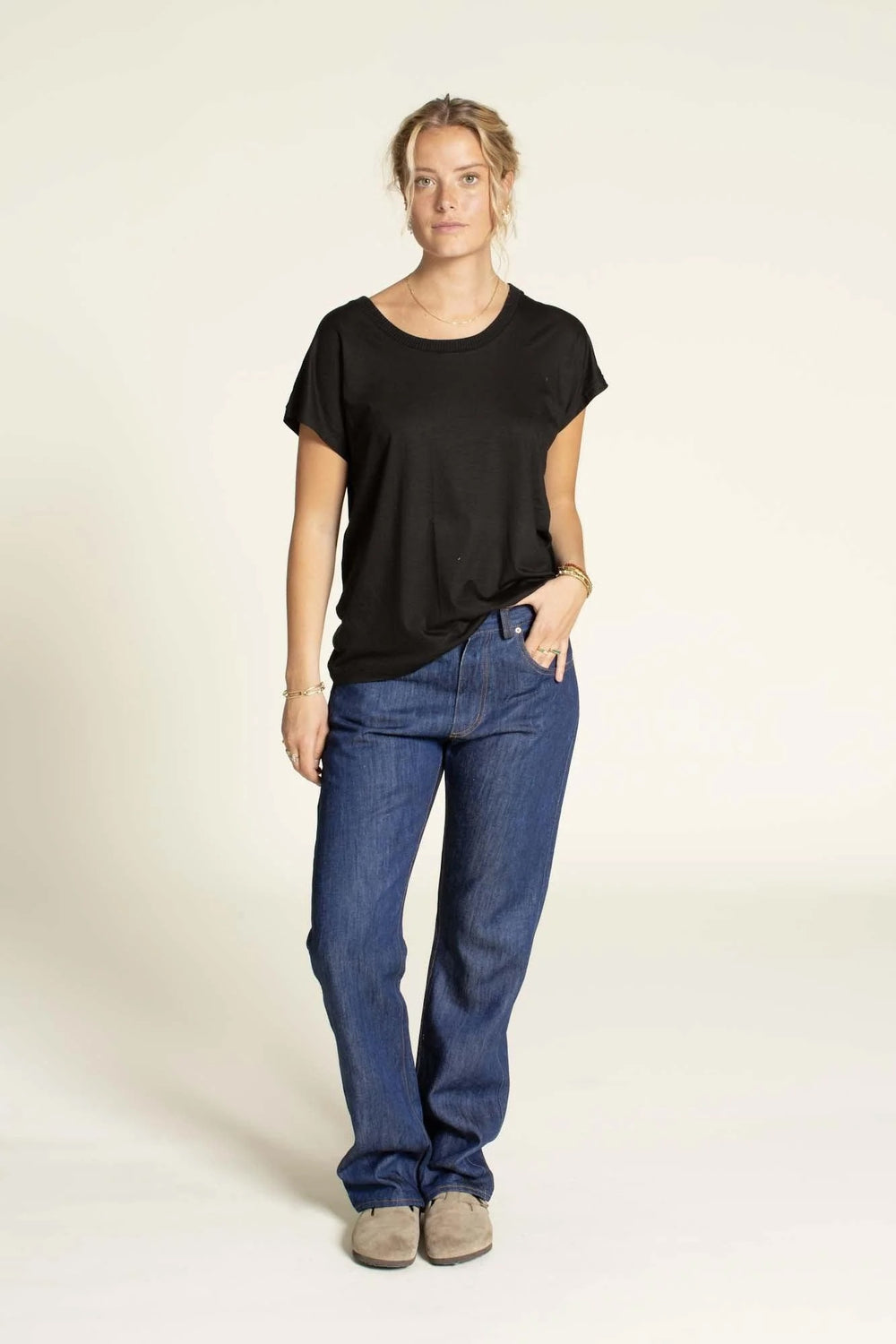 Woman wearing the Women's Jeans sewing pattern from Wardrobe by Me on The Fold Line. A jeans pattern made in non-stretch denim or canvas fabric, featuring a straight leg, curved waistband, front fly with zipper, back yoke, and classic five-pocket styling.