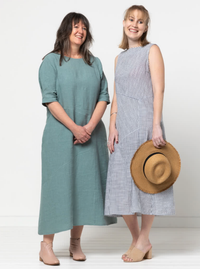 Women wearing the Yvette Woven Dress sewing pattern from Style Arc on The Fold Line. A dress pattern made in linen, crepe, rayon, or cotton fabric, featuring an A-line shape, boat neck, panelled asymmetrical design lines, sleeveless or elbow length sleeves, and midi length.