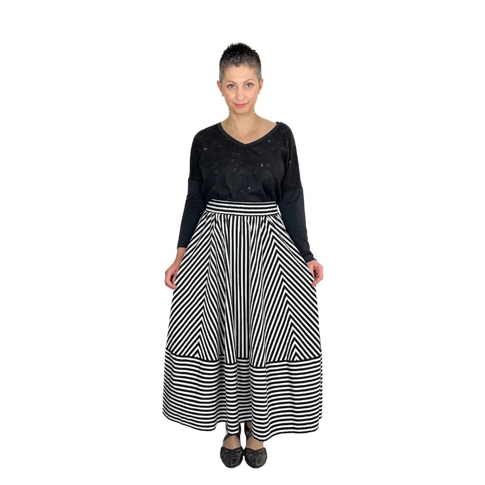 Woman wearing the Ziggy Skirt sewing pattern from Dhurata Davies Patterns on The Fold Line. A three-quarter circle skirt pattern made in cotton poplin fabric, featuring an elasticated waistband, panels, in-seam pockets, and a maxi length.