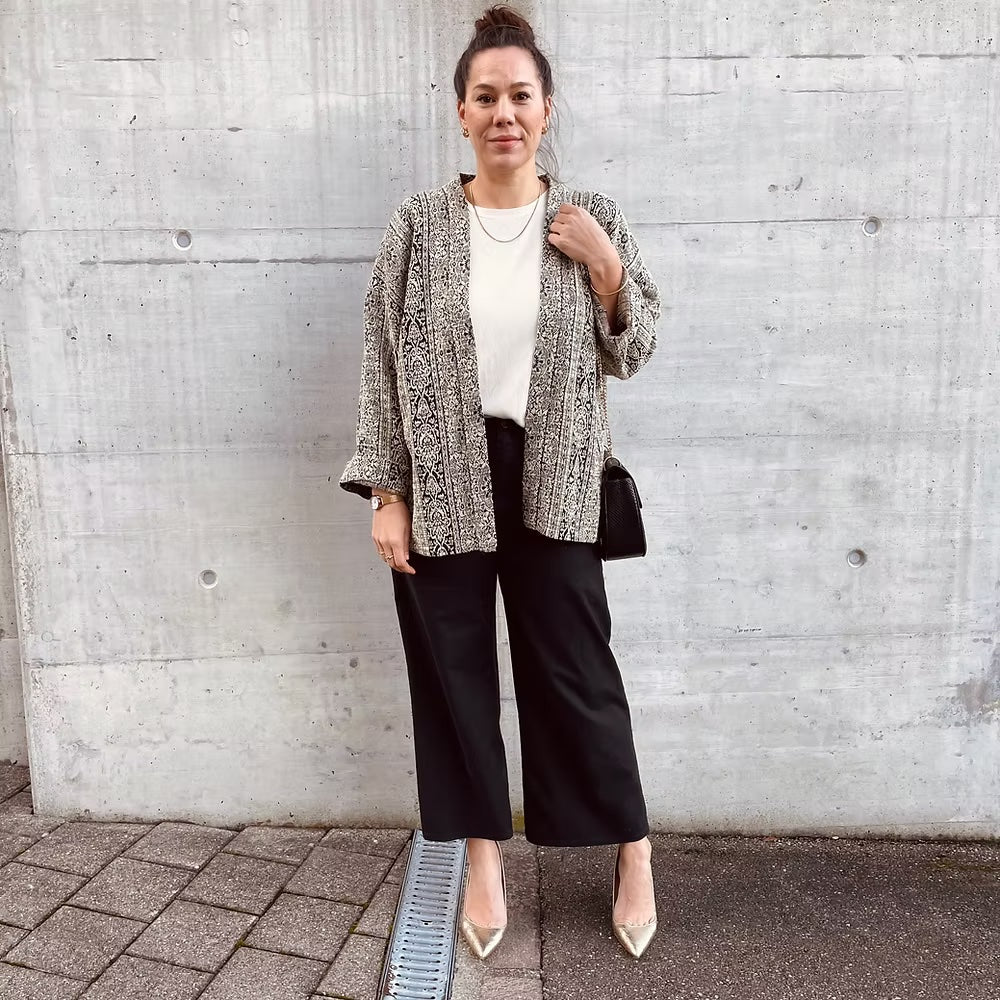 Woman wearing the Zoe Jacket sewing pattern from Sew.lala Patterns on The Fold Line. A jacket pattern made in cotton, linen, coating fabric, or boiled wool fabric, featuring a straight body, dropped shoulders, long cuffed sleeves, and hip length.