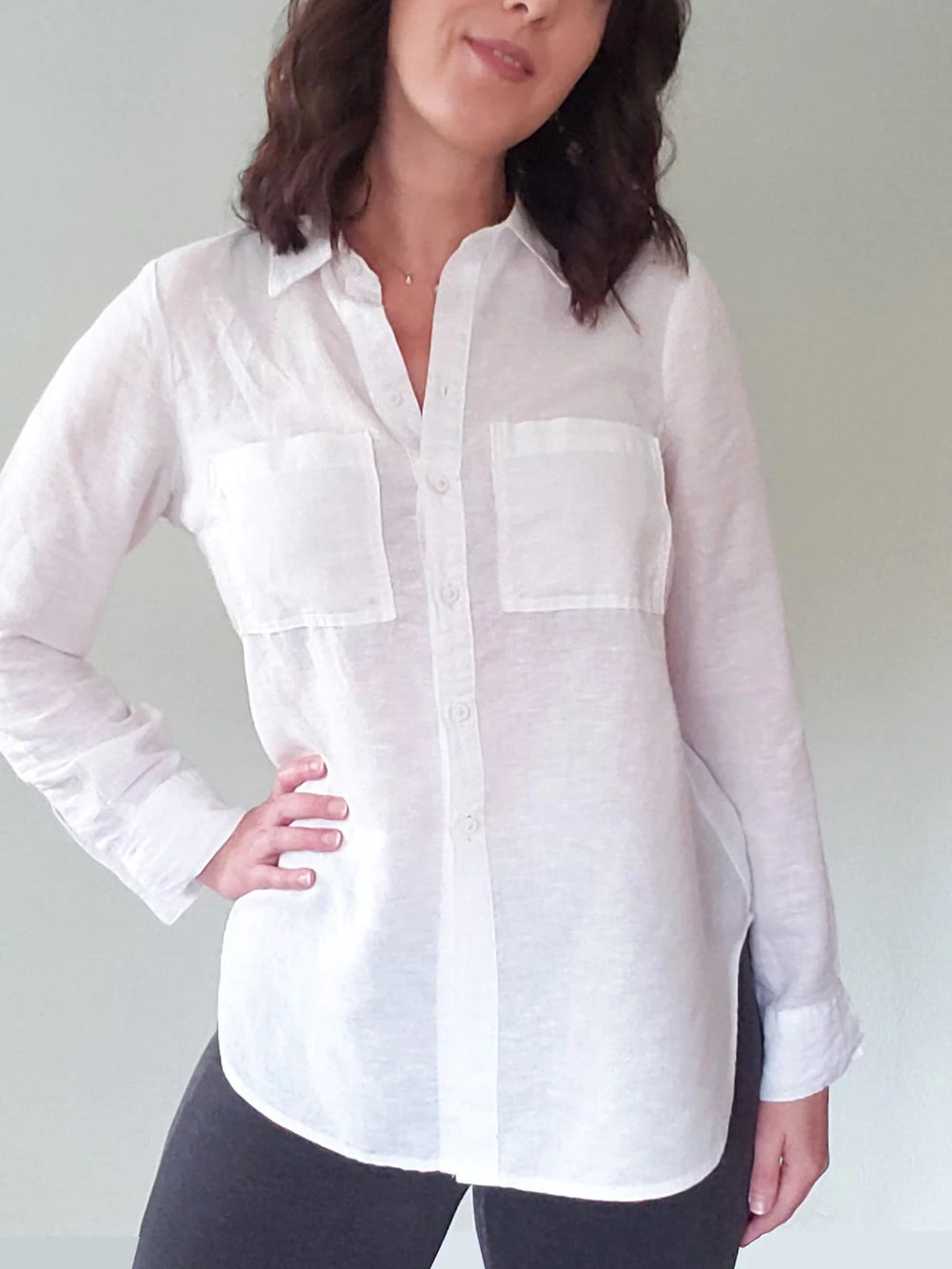 Woman wearing the Byrdie Button-up Blouse sewing pattern from Pattern Scout on The Fold Line. A blouse pattern made in light to medium weight woven fabrics, featuring a button front closure, long sleeves with button cuffs, straight point collar and breast