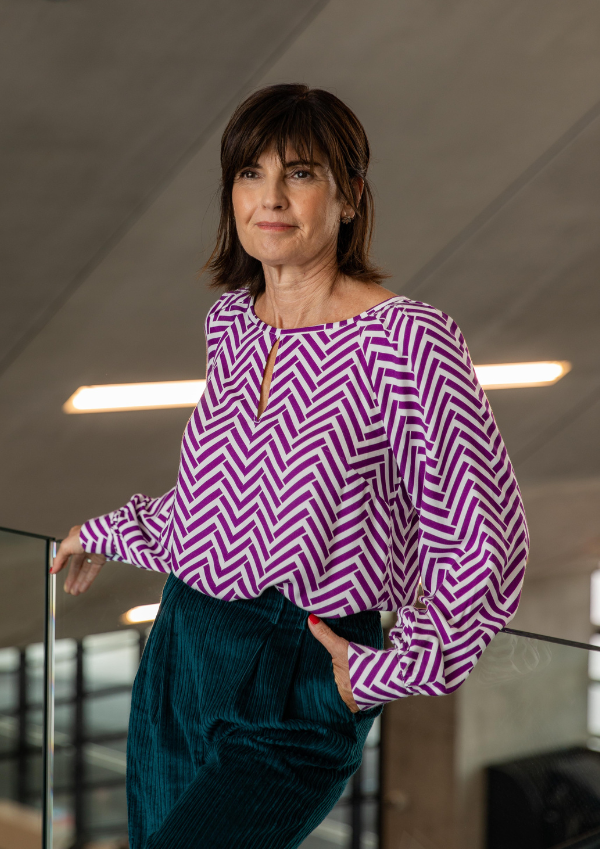 Woman wearing the Chelsea Blouse sewing pattern from Maison Fauve on The Fold Line. A blouse pattern made in viscose, tencel, cotton, crepe, poplin, satin, or twill fabrics, featuring a boat neckline with centre cut-out slit, long sleeves with cuffs and r
