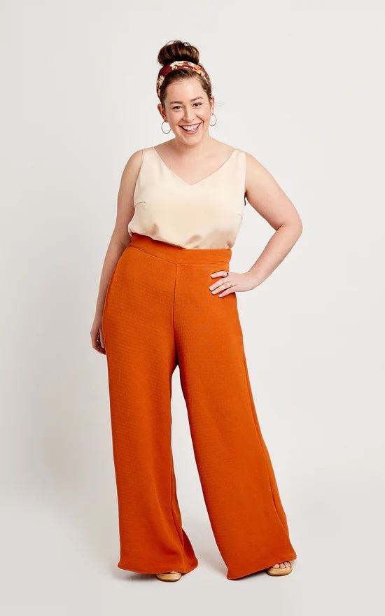 Woman wearing the Calder Trousers and Shorts sewing pattern from Cashmerette on The Fold Line. A trouser pattern made in rayon or polyester twill, tencel, linen, or chambray fabrics, featuring wide-legs, flat front, elasticated back waistband, faced in-se