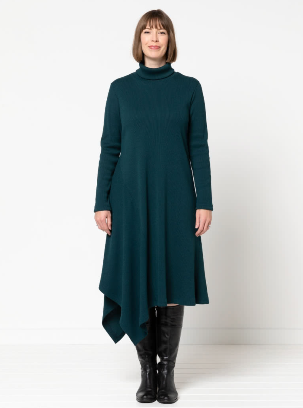 Woman wearing the Camile Knit Dress sewing pattern from Style Arc on The Fold Line. A dress pattern made in knit jersey, or knit rib fabrics, featuring a pull-on style, turtleneck, long sleeves, and asymmetrical hemline with side insert.