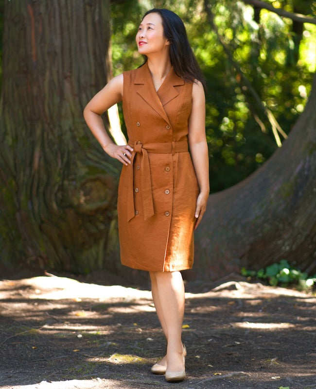 Woman wearing the Cantabria Dress sewing pattern from Itch to Stitch on The Fold Line. A dress pattern made in shirting, linen, chambray, rayon/viscose challis, and plain weave cotton fabrics, featuring a double-breasted front, lined, sleeveless, notched 