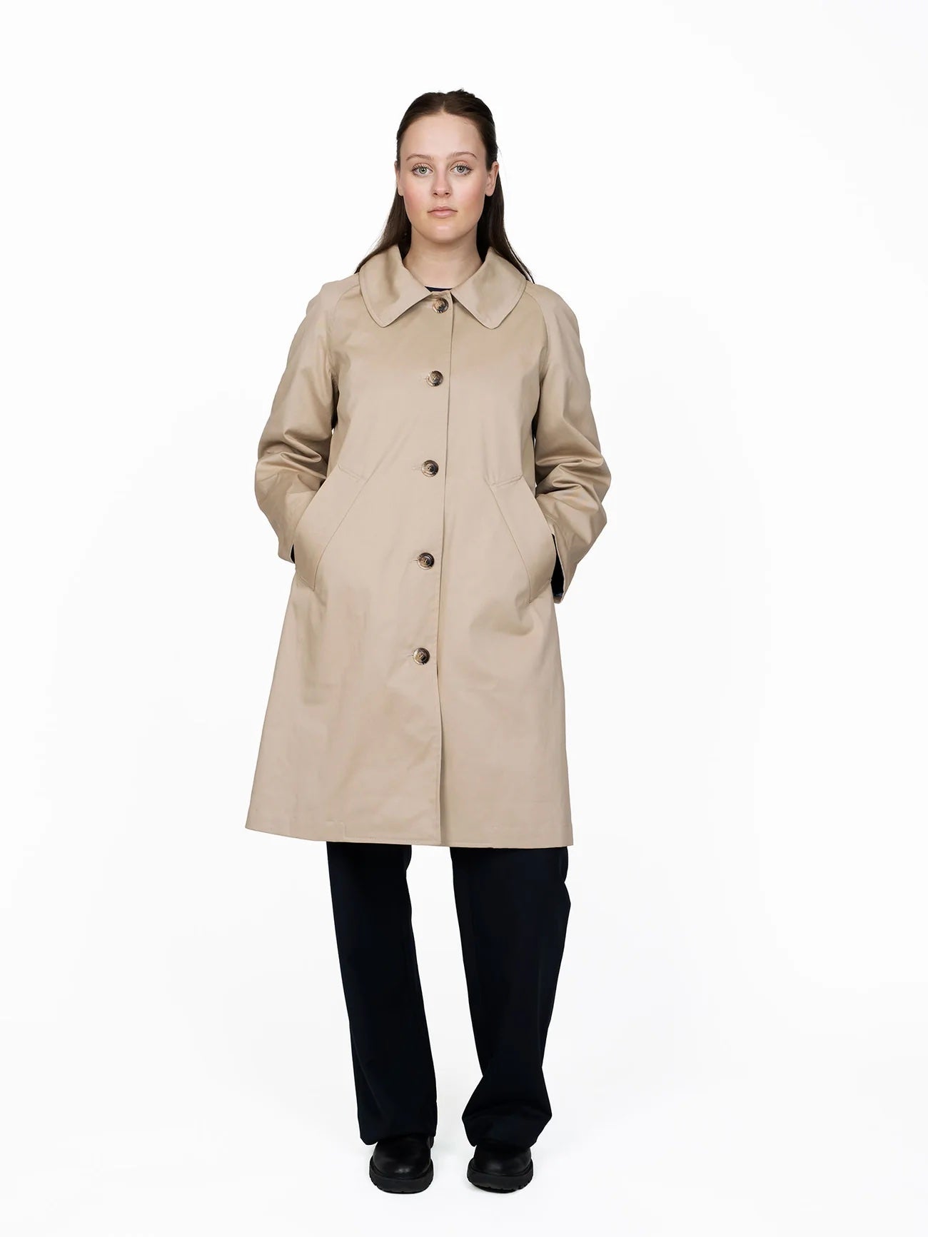 Woman wearing the Car Coat sewing pattern from The Assembly Line on The Fold Line. A coat pattern made in medium weight fabrics, featuring a slight A-line silhouette, relaxed fit, raglan sleeves, front welt pockets, with or without lining, front button cl