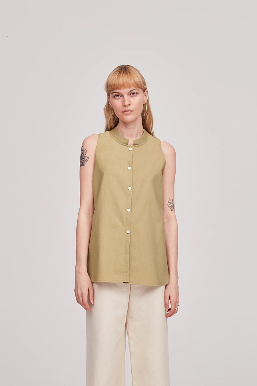 Woman wearing the Cara Top sewing pattern from The Modern Sewing Co on The Fold Line. A sleeveless top pattern made in poplin, muslin, Tencel or silk fabrics, featuring a square officer collar, front button closure, small bust darts and gentle A-line silh
