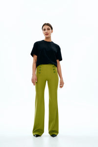 Woman wearing the Carla Trousers sewing pattern from Vikisews on The Fold Line. An trouser pattern made in wool suiting or gabardine fabrics, featuring a close-fit, flared from the knee down, no waist band but facing finish, side panels that imitate slash