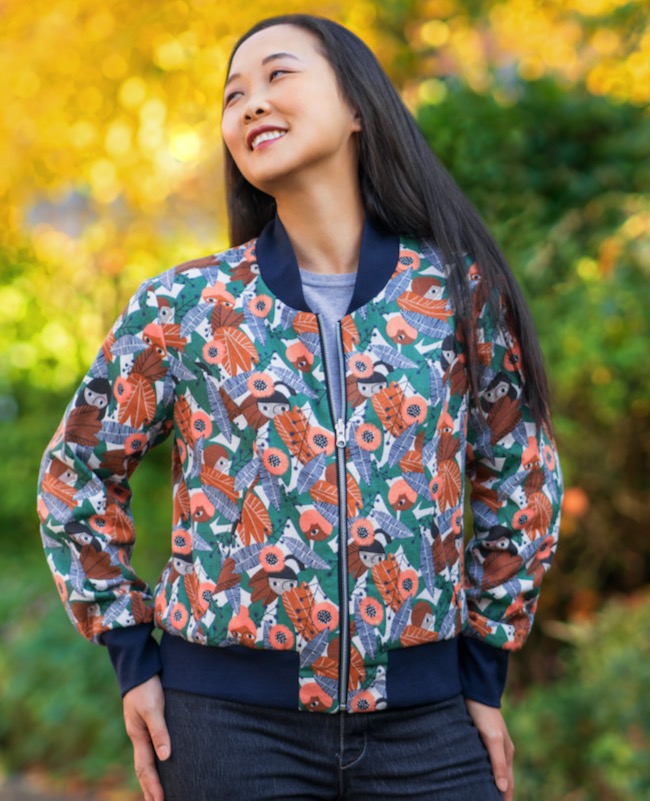Woman wearing the Causeway Bomber Jacket sewing pattern from Itch to Stitch on The Fold Line. A jacket pattern made in nylon, cotton, rayon twill, or crepe fabrics, featuring a hip length, ribbed collar, waistband and cuffs, front princess seams, invisibl