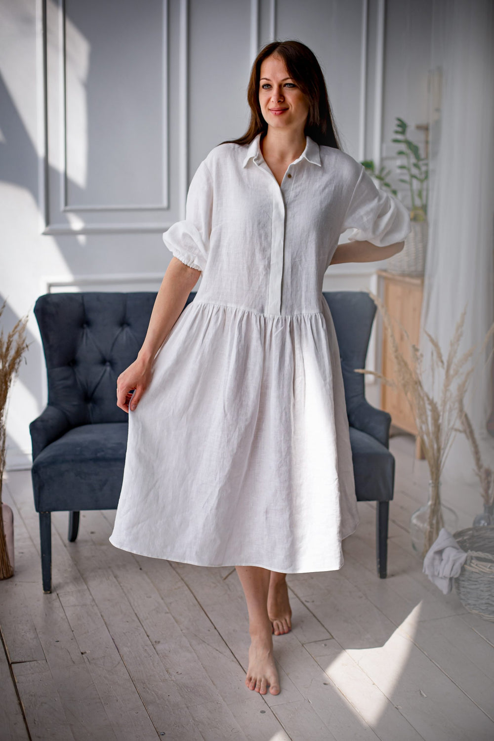 Woman wearing the Cecilie Dress sewing pattern from Kates Sewing Patterns on The Fold Line. A dress pattern made in linen or cotton fabrics, featuring a loose fit, dropped waistline, below knee length, bust darts, button placket, shirt collar, back yoke, 