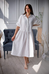 Woman wearing the Cecilie Dress sewing pattern from Kates Sewing Patterns on The Fold Line. A dress pattern made in linen or cotton fabrics, featuring a loose fit, dropped waistline, below knee length, bust darts, button placket, shirt collar, back yoke, 