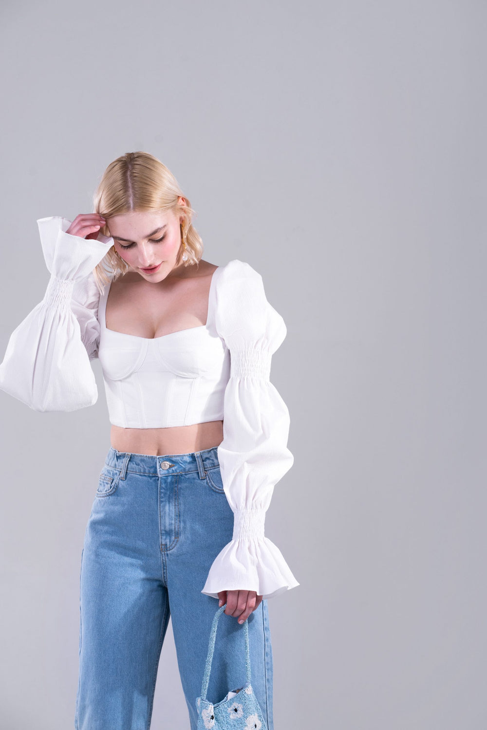 Woman wearing the Chiara Top sewing pattern from Vikisews on The Fold Line. A corset top pattern made in cotton, cotton shirting, linen or lightweight denim fabrics, featuring a tight-fit, separate bust cups, front and back rigilene boning, back separatin