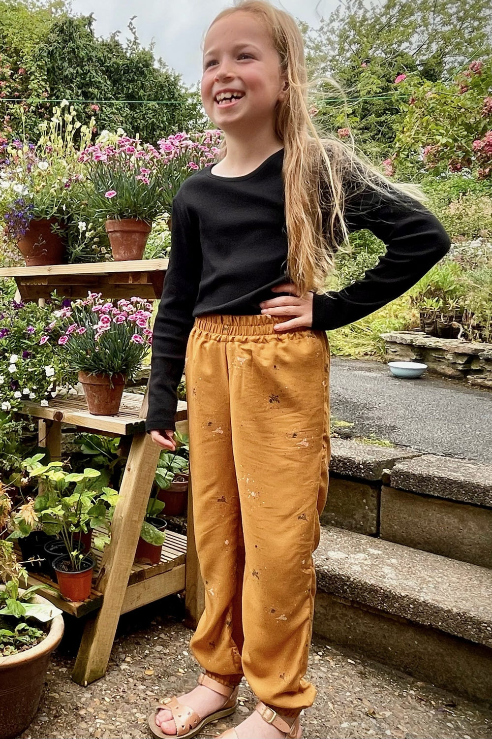 Child wearing the Baby/Child Wayfinder Pants/Trousers sewing pattern from Waves & Wild on The Fold Line. A trouser pattern made in viscose, rayon, silk, poplin, lawn, linen blends or chambray fabrics, featuring an elasticated waist and ankles, real or fau