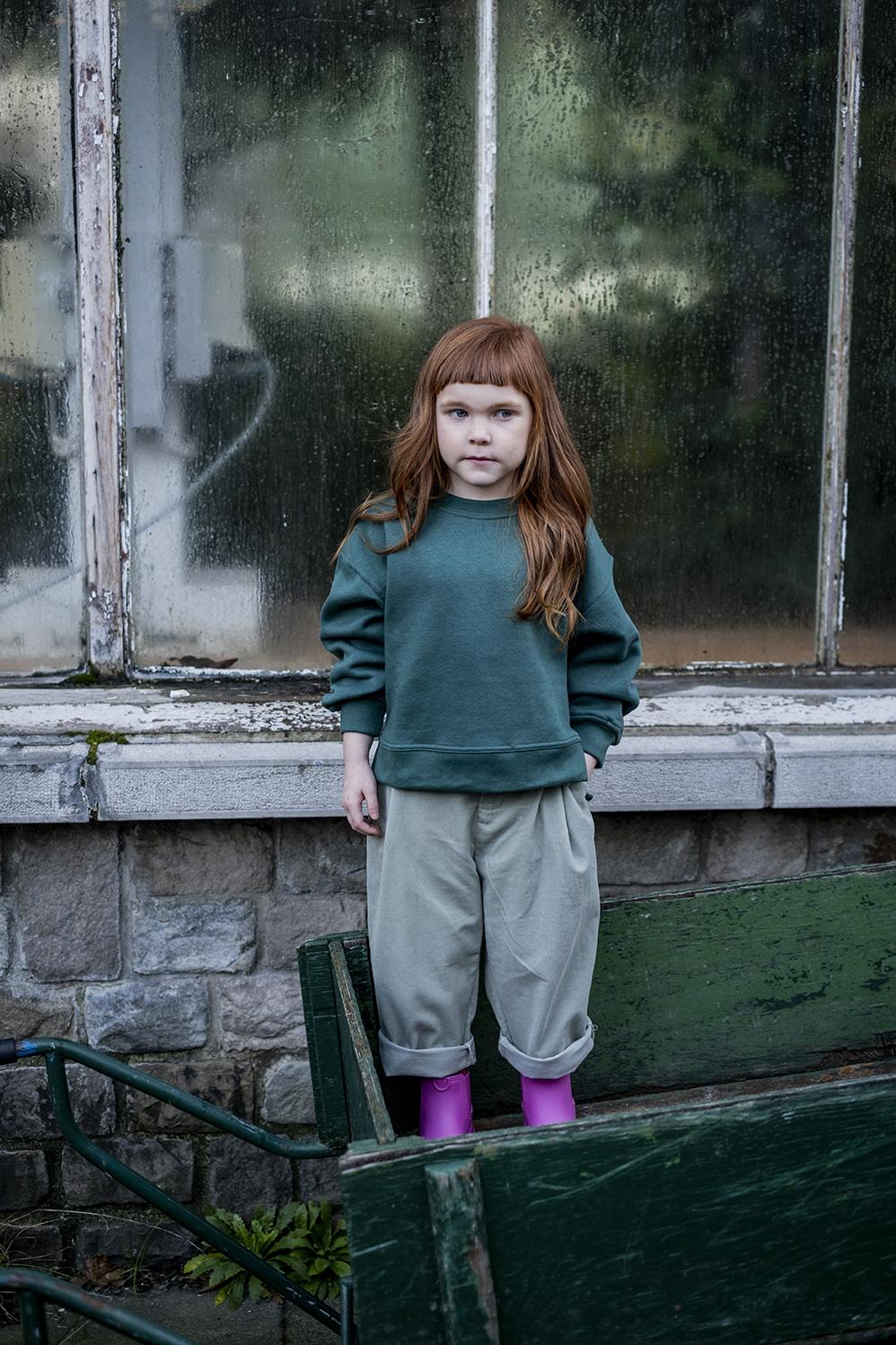 Child wearing the Child/Teen Chris Trousers sewing pattern from Fibre Mood on The Fold Line. A trouser pattern made in corduroy, denim, cotton twill, gabardine, linen, lyocell or flannel fabrics, featuring a fly zip, adjustable elastic waistband, side sea