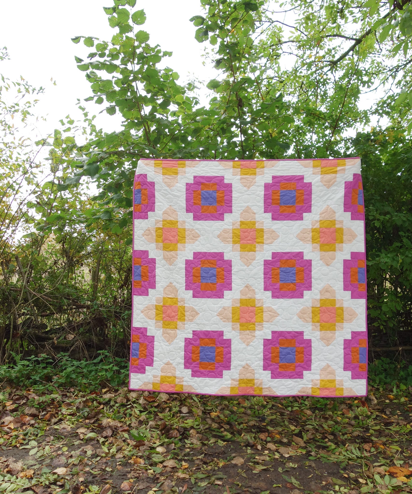 Photo showing the City Lights Quilt sewing pattern from Lou Orth Designs on The Fold Line. A quilt pattern made in quilting cotton fabrics, featuring a fun, modern quilt design that can be made in three sizes.