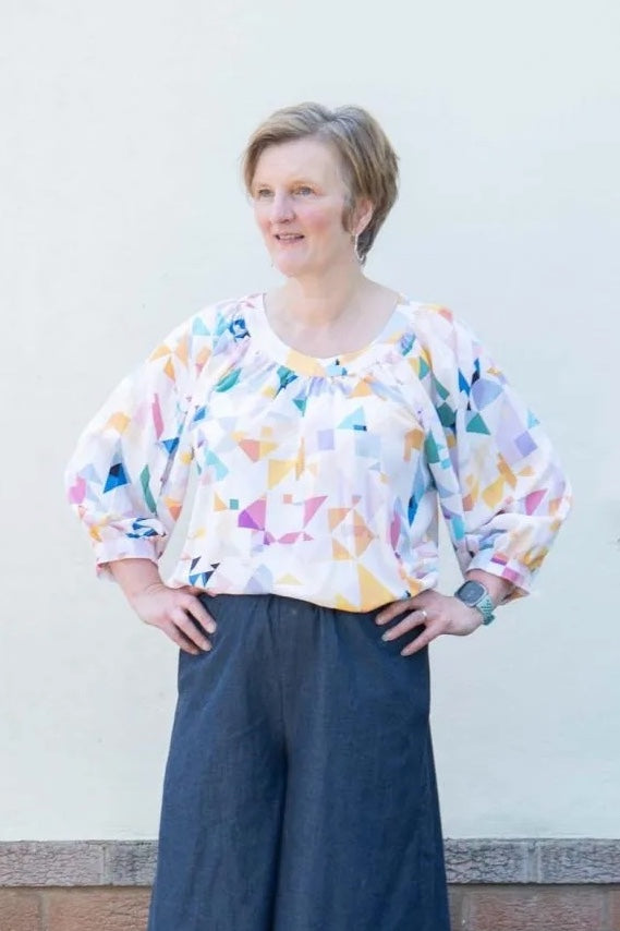 Woman wearing the Claire Top sewing pattern from Bobbins and Buttons on The Fold Line. A top pattern made in cotton lawn, poplin, viscose, lyocell, linen, or linen blend fabric, featuring a loose easy fit, softly gathered neckline, and 3/4 raglan sleeves.