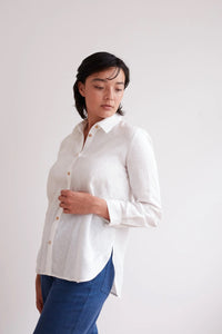 Woman wearing the Classic Shirt sewing pattern from The Modern Sewing Co on The Fold Line. A shirt pattern made in cotton or linen fabrics, featuring a semi-fit, back yoke with deep pleat, deep scoop hem, full length sleeve with button hem and front butto
