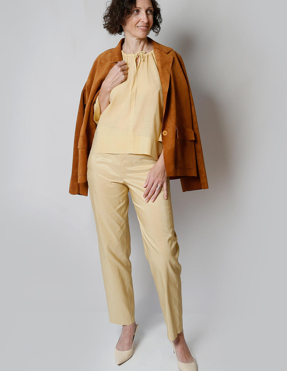 Woman wearing the Classic Trouser sewing pattern from The Maker's Atelier on The Fold Line. A Trouser pattern made in cottons, linens, denim, wool flannel or poly/viscose crepe fabrics, featuring a straight-leg, side zip, no waistband, back waist darts an