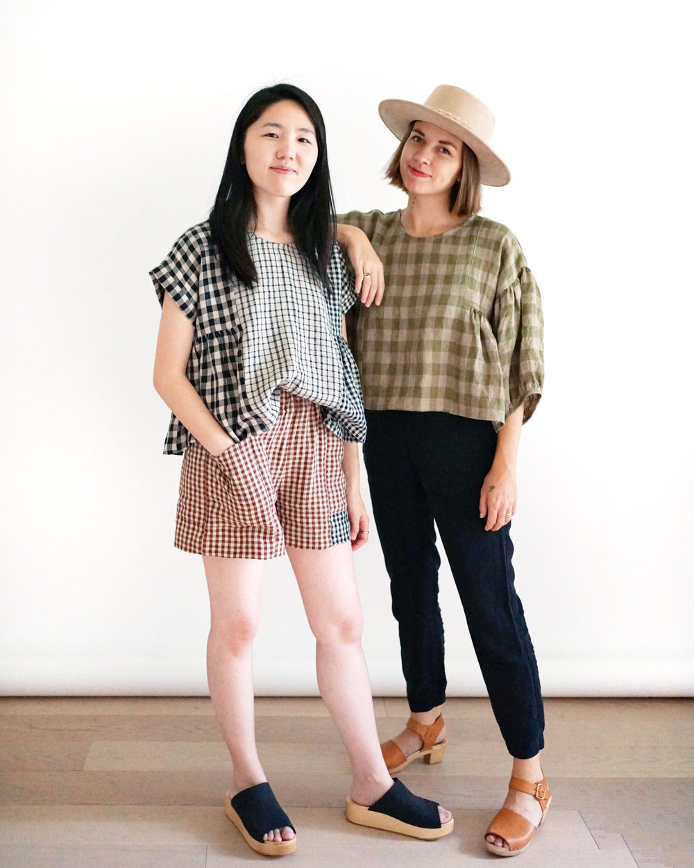 Women wearing the Collage Gather Top sewing pattern from Matchy Matchy Sewing Club on The Fold Line. A top pattern made in light to medium weight woven fabrics, featuring a round neck, boxy silhouette, slightly cropped length, gathered side panels, cuff o