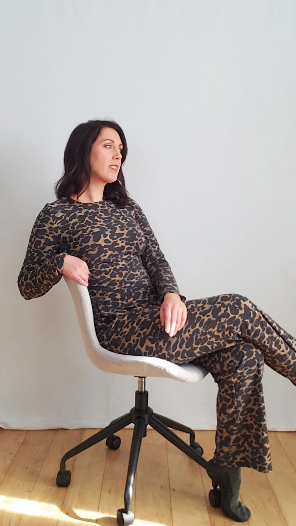 Woman wearing the Comfi Tee and Pants Lounge Set sewing pattern by Pattern Scout. A T-shirt and pants pattern made in two-way and four-way stretch, light to medium weight knit fabrics, featuring a T-shirt top with a round neck and long sleeves. The pants 