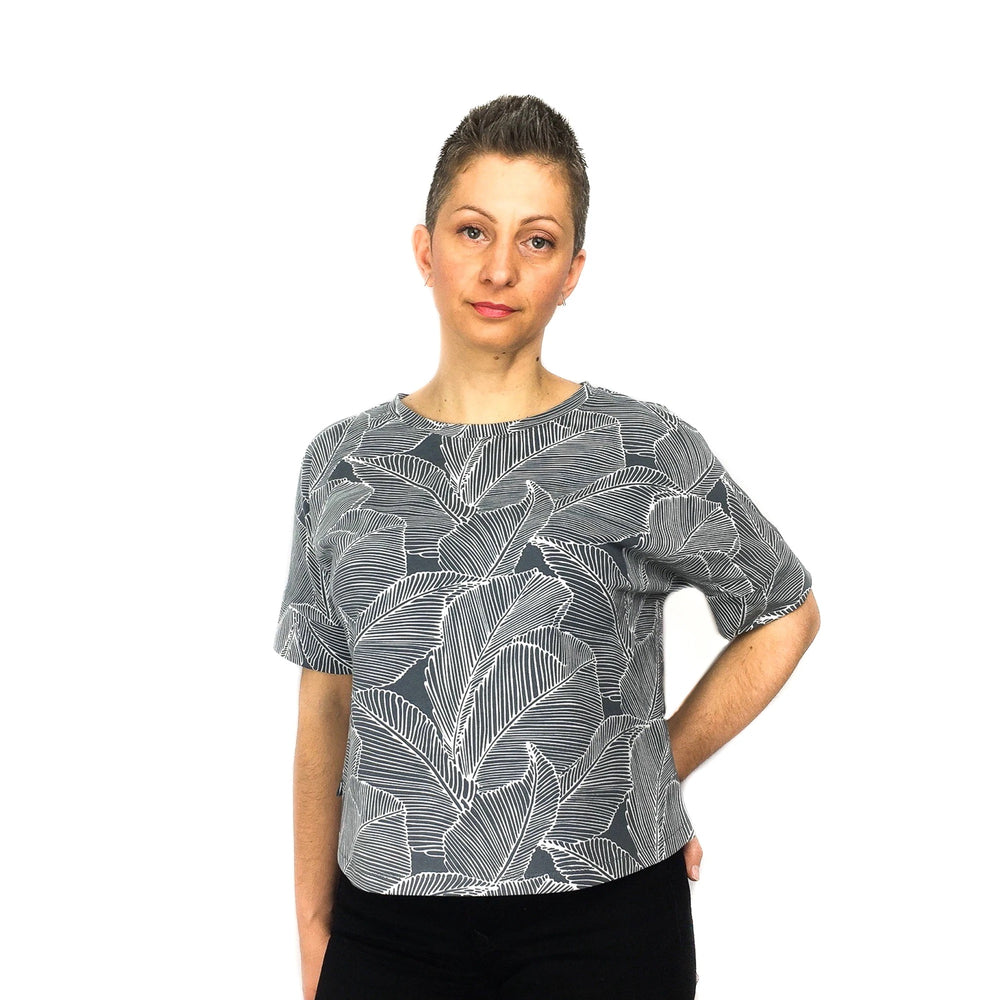 Woman wearing the Cora Tee sewing pattern from Dhurata Davies Patterns on The Fold Line. A T-shirt pattern made in light to medium weight knit/jersey fabrics, featuring a boxy shape, contrasting centre back panel, round neckline, elbow length sleeves, sid