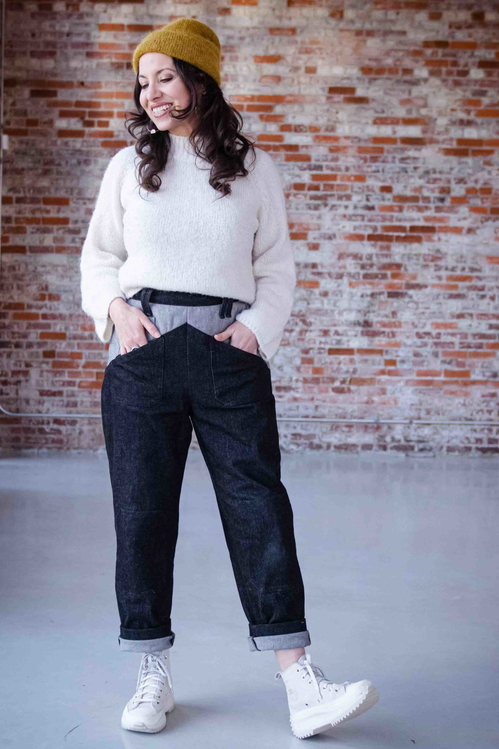 Woman wearing the Cosecha Pants sewing pattern from Sew Liberated on The Fold Line. A trouser pattern made in denim, twill or canvas fabrics featuring a tapered leg, angled front and back patch pockets, coin pocket, fitted curved waistband, darts on the b