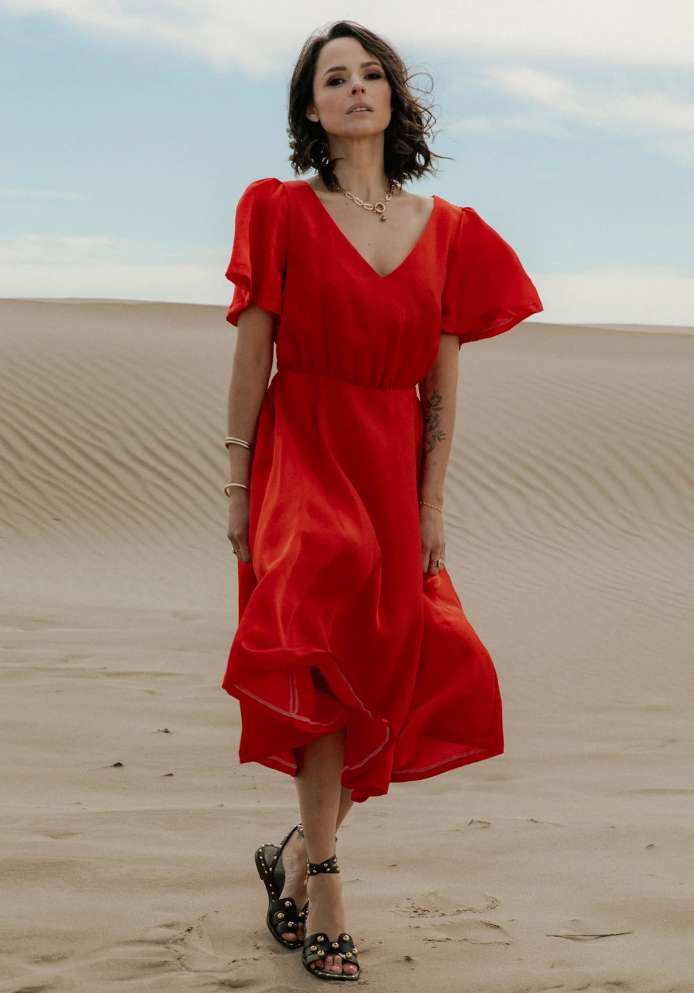 Woman wearing the Cuba Libre Dress sewing pattern from Maison Fauve on The Fold Line. A dress pattern made in woven fabrics with a soft drape including twill, viscose crepe or poplin, fine jacquard, or even lace fabric, featuring a v-neck, butterfly sleev