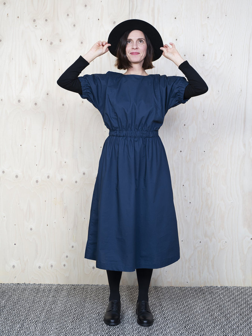 Woman wearing the Cuff Dress sewing pattern from The Assembly Line on The Fold Line. A dress pattern made in cotton, silk, lawn, linen, crepe de chine or wool crepe fabrics, featuring a mid-length finish, relaxed fit, round neck with keyhole opening in th