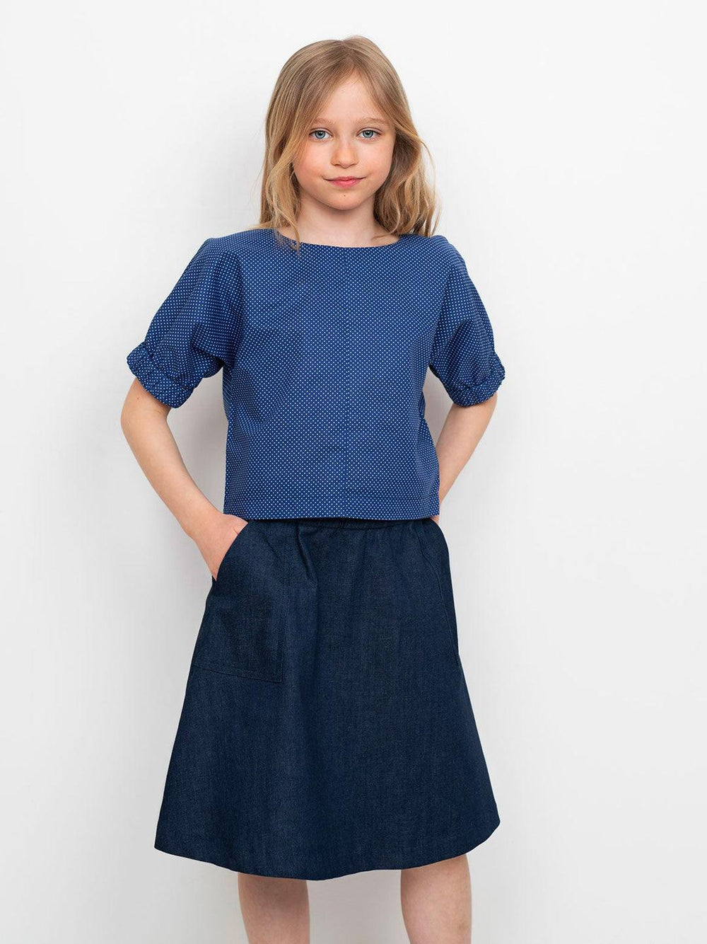 Child wearing the Children's Cuff Top Mini sewing pattern from The Assembly Line on The Fold Line. A top pattern made in light to mid-weight fabrics, featuring a straight fit, round neck, keyhole opening with snap fastener at the back and cap sleeves with
