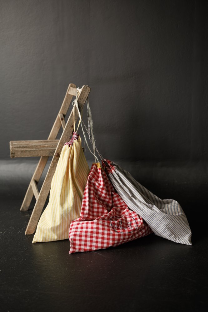 Photo showing the Drawstring Bag sewing pattern from Merchant & Mills on The Fold Line. A bag cover pattern made in linen, brushed cotton, Indian handlooms, cotton block prints, hemp blends, wool, cotton corduroy and needlecord fabrics, featuring a rectan