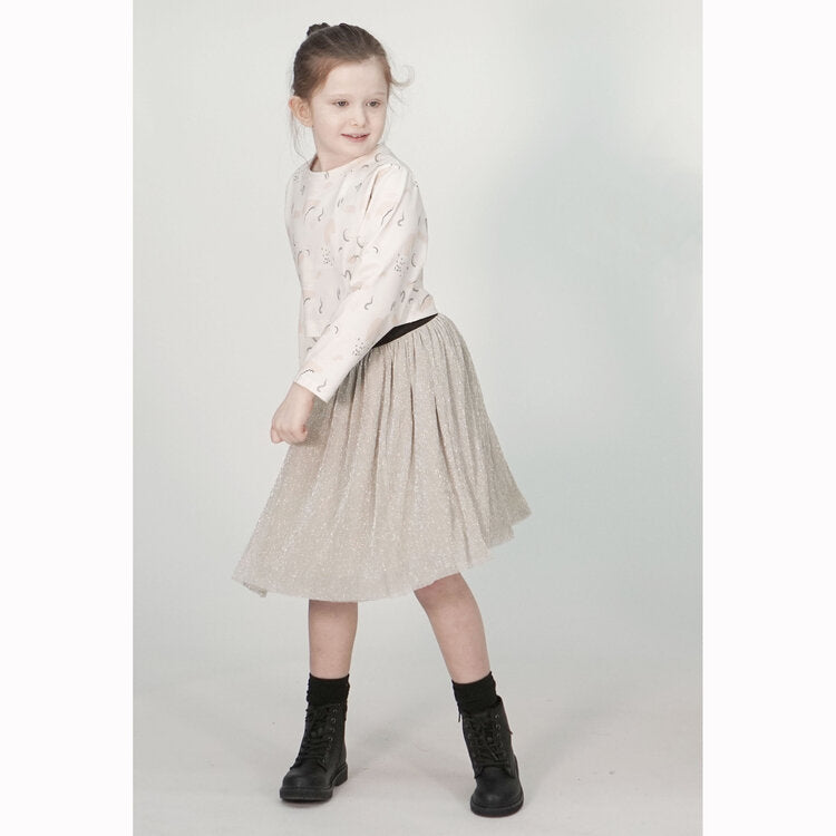 Child wearing the Child Rainee Skirt sewing pattern from Pattern Paper Scissors on The Fold Line. A skirt pattern made in tulle, netting, chiffon, georgette, crinkle, lace or voile fabrics, featuring two layers of fabric, lining, exposed elastic waistband