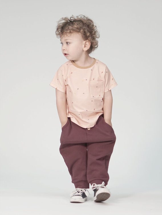 Child wearing the Addison Slouch Pant sewing pattern from Pattern Paper Scissors on The Fold Line. A trouser pattern made in jersey, sweat, terry, stretch crepe or knit fabrics, featuring a tapered leg, dropped crotch, elasticated waist, side pockets, “fa
