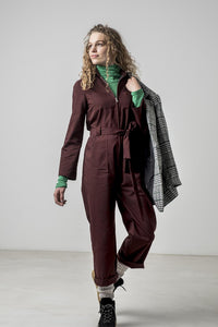 Woman wearing the Leah Jumpsuit sewing pattern from Fibre Mood on The Fold Line. A boilersuit/workwear overall pattern made in cotton, denim or corduroy fabrics, featuring topstitching, chest pockets, hip pockets, back yoke, belt and belt loops, front zip