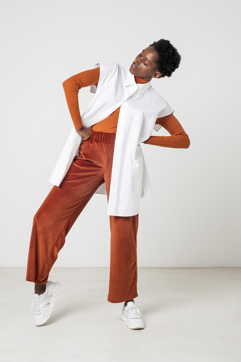 Woman wearing the Benita Trousers sewing pattern from Fibre Mood on The Fold Line. A trouser pattern made in interlock, French terry, sweatshirt knit, velour jersey, ribbed jersey or woven crepe fabrics, featuring an elasticated waistband, straight leg, a
