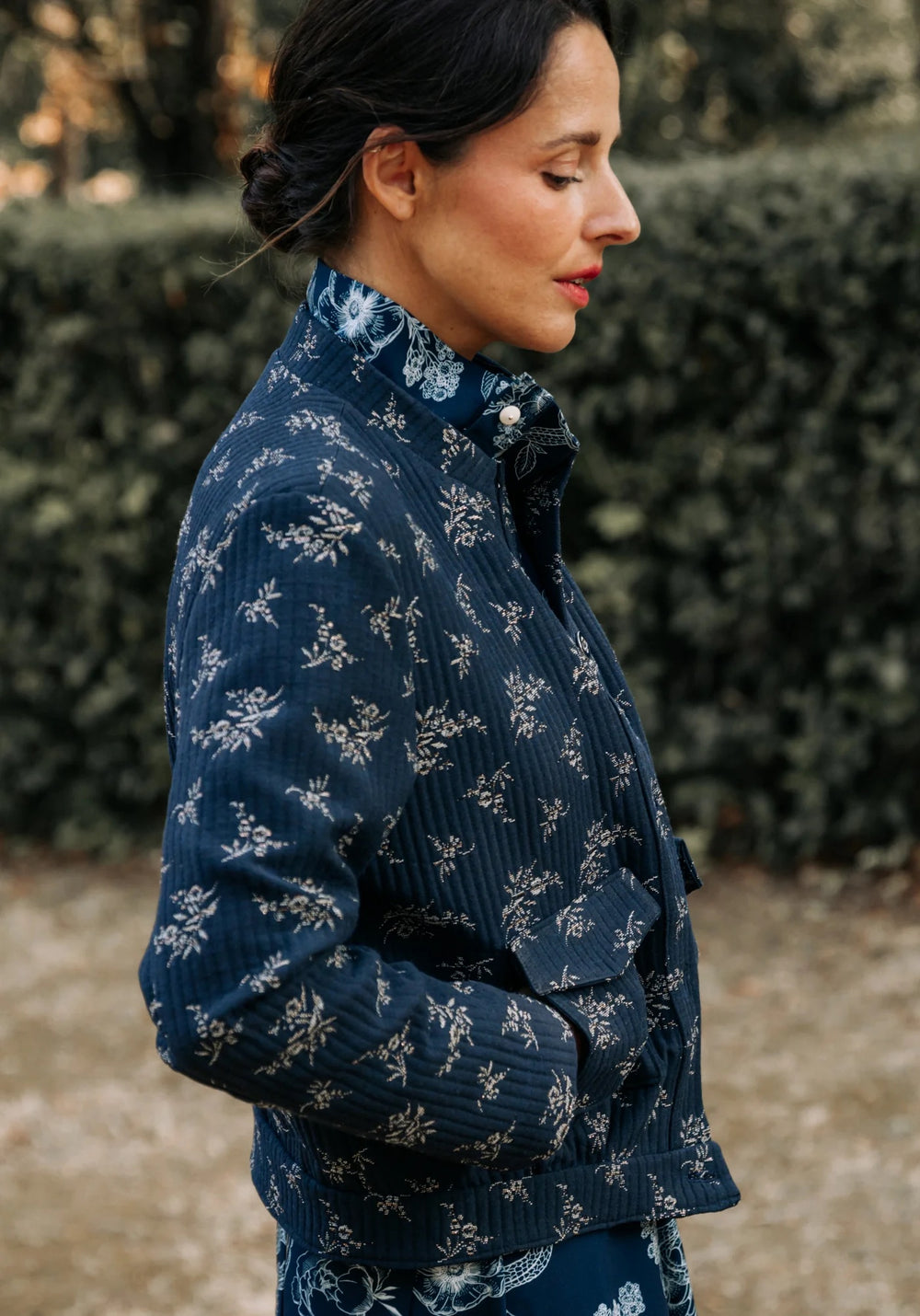 Woman wearing the Dandelion Jacket sewing pattern from Maison Fauve on The Fold Line. A jacket pattern made in jacquard, wool, tweed, denim, or gabardine fabrics, featuring a waistband, button front closure, back pleats, stand collar, and front patch pock