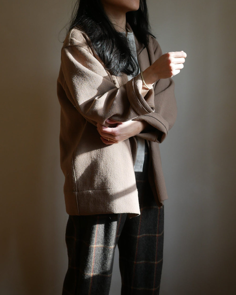 Woman wearing the Daphne Jacket sewing pattern from Vivian Shao Chen on The Fold Line. A jacket pattern made in wool coating, boiled wool, tweed, flannel, double-faced fabric, or quilted fabric, featuring a shawl collar, open front, oversized and boxy fit
