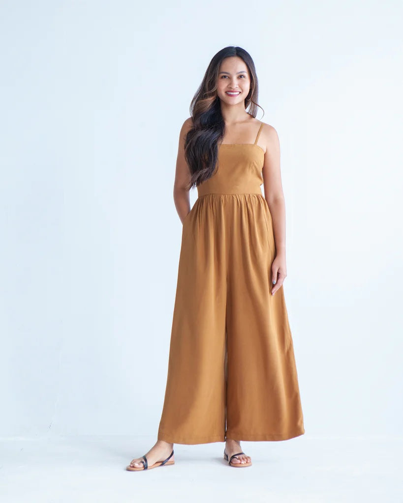 Woman wearing the Darla Jumpsuit sewing pattern from True Bias on The Fold Line. A jumpsuit with spaghetti straps, a gathered waist, wide legs, and in-seam pockets.