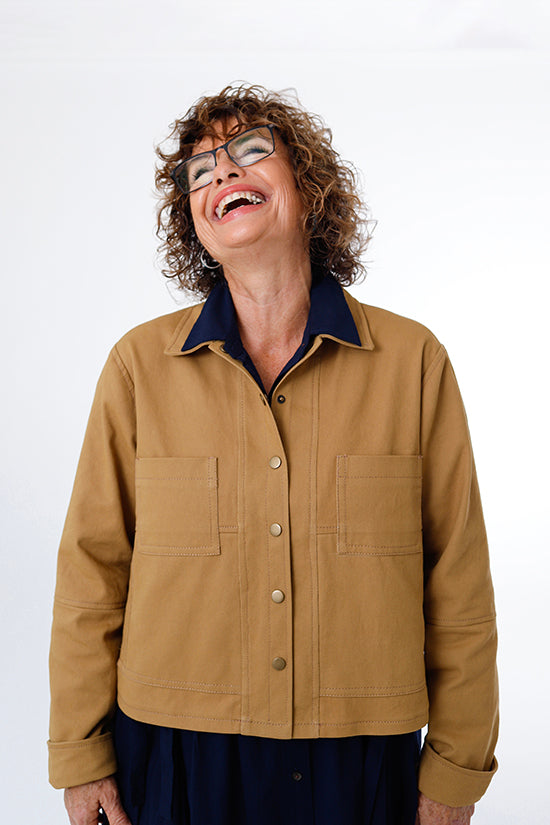 Woman wearing the Den Jacket sewing pattern from Chalk and Notch on The Fold Line. A jacket pattern made in canvas, corduroy, denim, flannel, linen, or twill fabrics, featuring an optional lining, topstitching, collar, fold-up cuff, centre front snap clos
