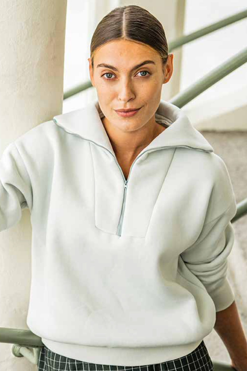 Woman wearing the Didi Pullover sewing pattern from Fibre Mood on The Fold Line. A jumper pattern made in chunky knit fabric, French terry, sweatshirt fabric, ribbed knit or knit jacquard fabrics, featuring an oversized fit, large collar with zip opening 