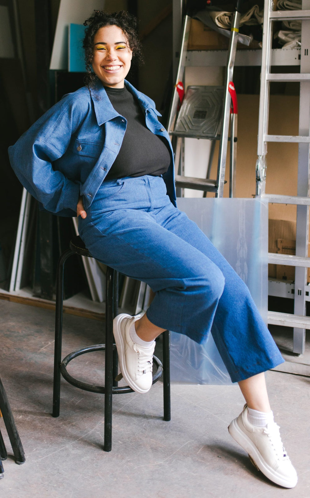 Woman wearing the Dina Jeans sewing pattern from JULIANA MARTEJEVS on The Fold Line. A jeans pattern made in stretch denim fabrics, featuring a fly zip closure, front and back pockets, cropped length, belt loops, semi fitted and slight flare from the knee