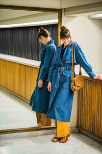 Woman wearing the Drea Trench Coat sewing pattern from Fibre Mood on The Fold Line. A coat pattern made in gabardine, cotton twill, nylon or denim fabrics, featuring a midi length, front and back storm flaps, belted waist, collar and lapels, back split, p