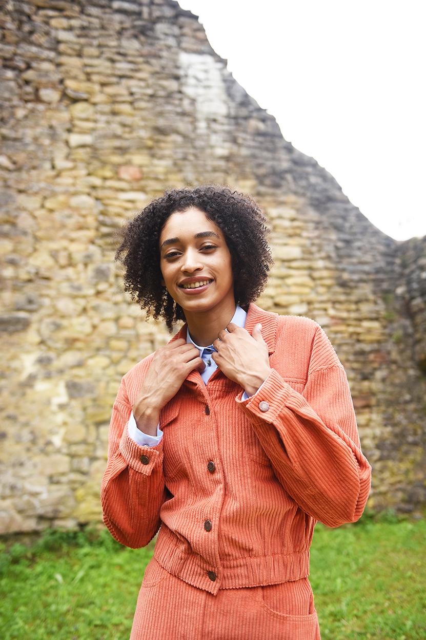 Woman wearing the Drew Jacket sewing pattern from Fibre Mood on The Fold Line. A denim jacket pattern made in corduroy, denim, cotton or wool coating fabrics, featuring a cropped length, long sleeves with button cuffs, two chest pockets, traditional colla