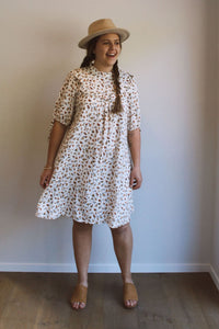 Woman wearing the Dua Dress sewing pattern by Makyla Creates. A dress pattern made in cotton’s, linen’s or rayon fabrics, featuring a relaxed fit, stand collar, button up shoulder placket closure, front and back bib with ruffle, front and back gathering u