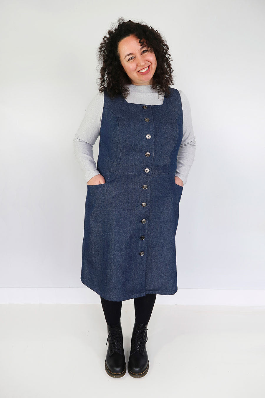 Woman wearing the Dulcie Pinafore sewing pattern from Jennifer Lauren Handmade on The Fold Line. A pinafore dress pattern made in denim, corduroy, wool, suitings, tweeds and mammoth flannel fabrics, featuring a button-front, square neckline, semi-fitted A